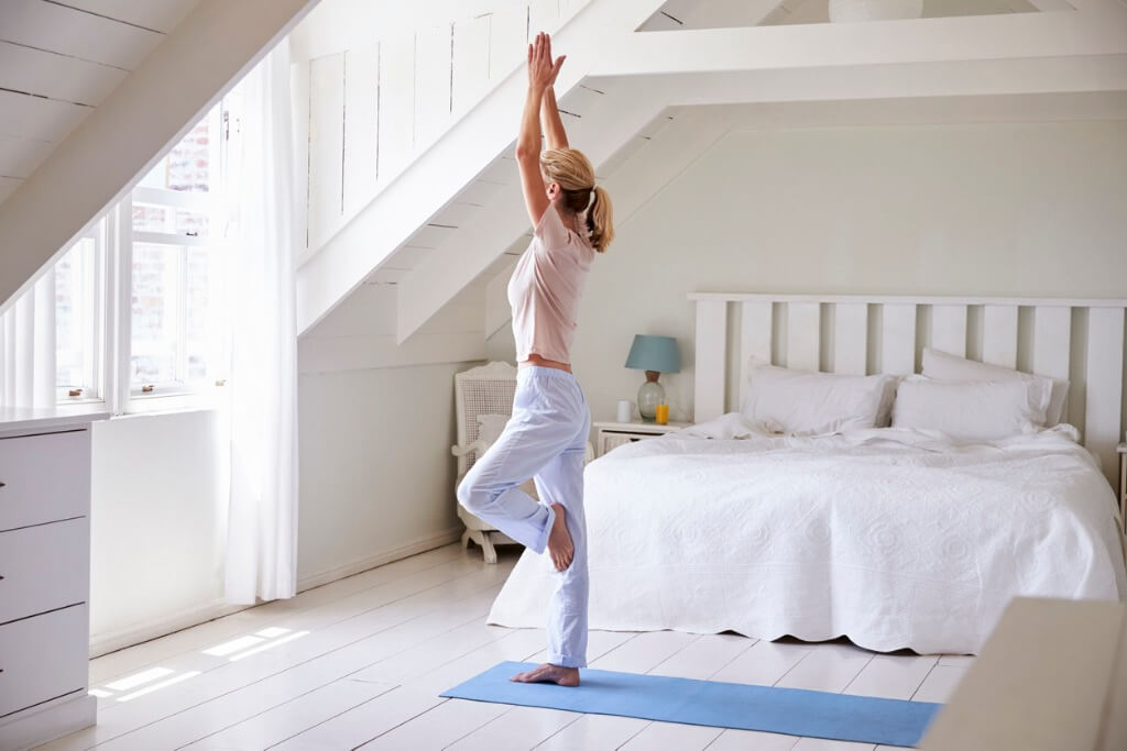 Mujer haciendo yoga en casa