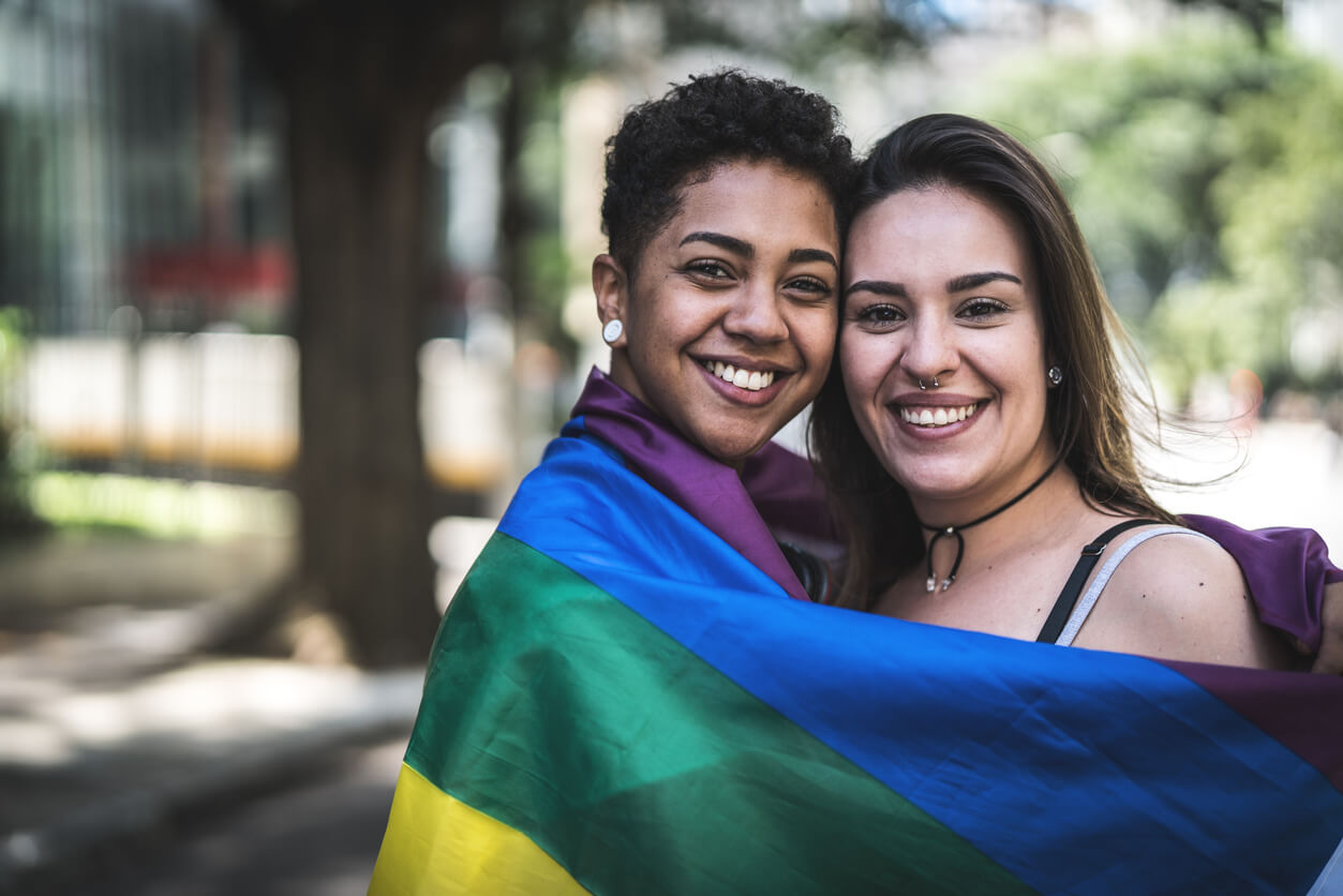 Pareja de lesbianas con la bandera del arco iris