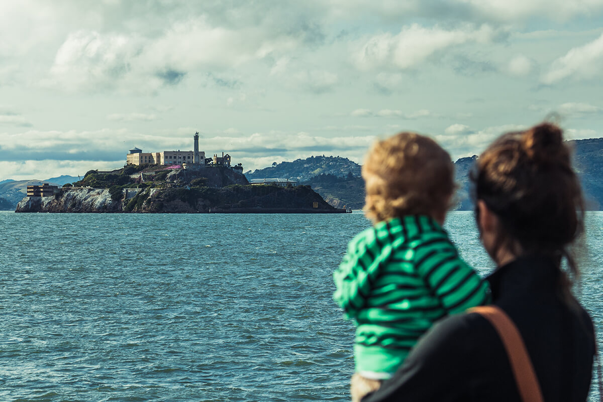 madre y su hijo miran al horizonte donde se ve la prisión de Alcatraz