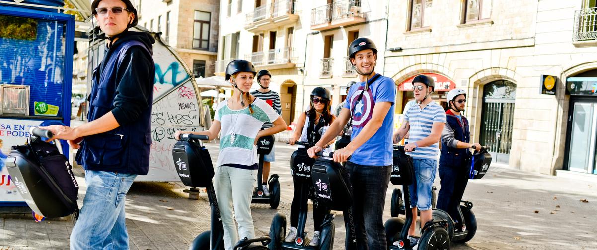 Chicos moviéndose en Segway por la ciudad